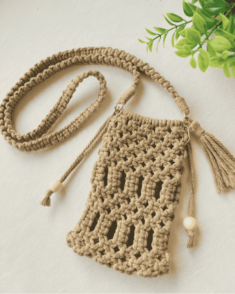 Full handmade macramé crossbody phone bag in light brown with boho-style strap and tassels