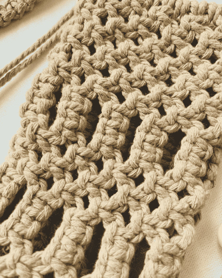 Close-up view of handmade macramé phone bag showing detailed knots in light brown cotton cord