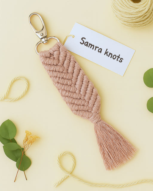 Soft pink macramé keychain placed on a minimal boho flatlay with green and yellow accents – Samra Knots.