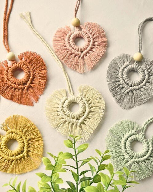 Handmade heart-shaped macramé car diffusers in soft boho colors with wooden beads, styled on a neutral background – Samra Knots.