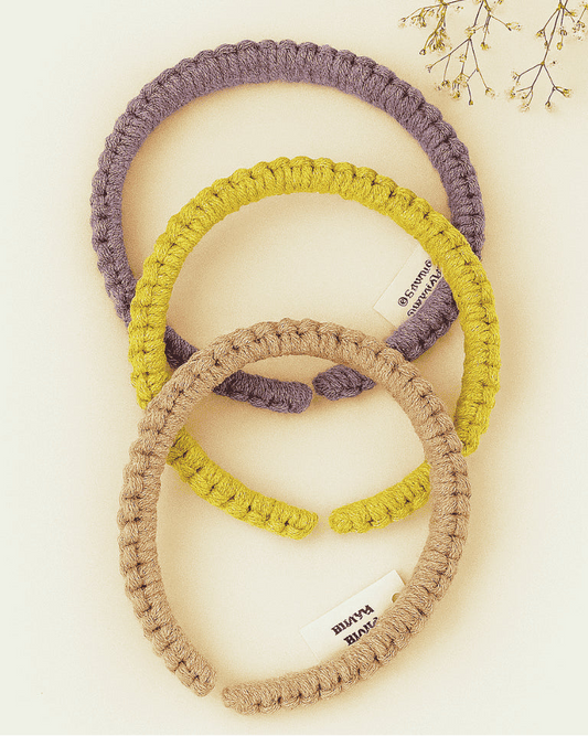 Three handmade macramé headbands in lavender, mustard yellow, and blush pink, styled on a neutral background with dried flowers – Samra Knots boho accessory.